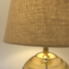 Close up of natural hessian linen round tapered shade with gold neck