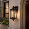 Classic black outdoor wall light with clear glass panels styled on rendered porch wall in contemporary exterior setting